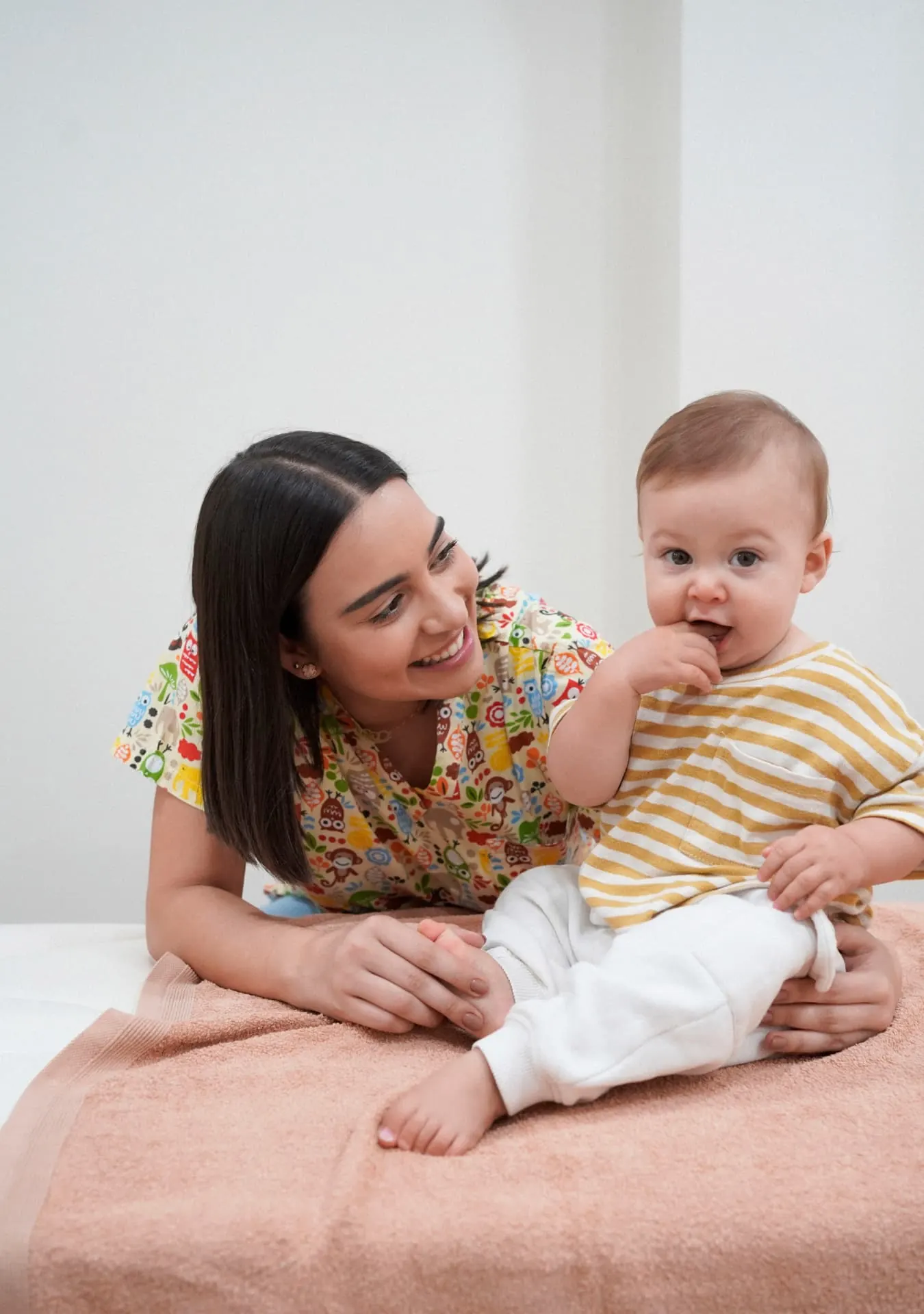 Bebé tranquilo e sorridente ao colo durante a consulta